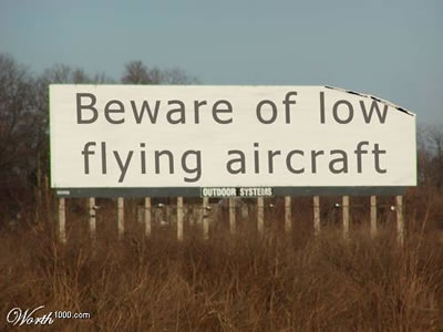 Beware of low flying aircraft sign with corner missing